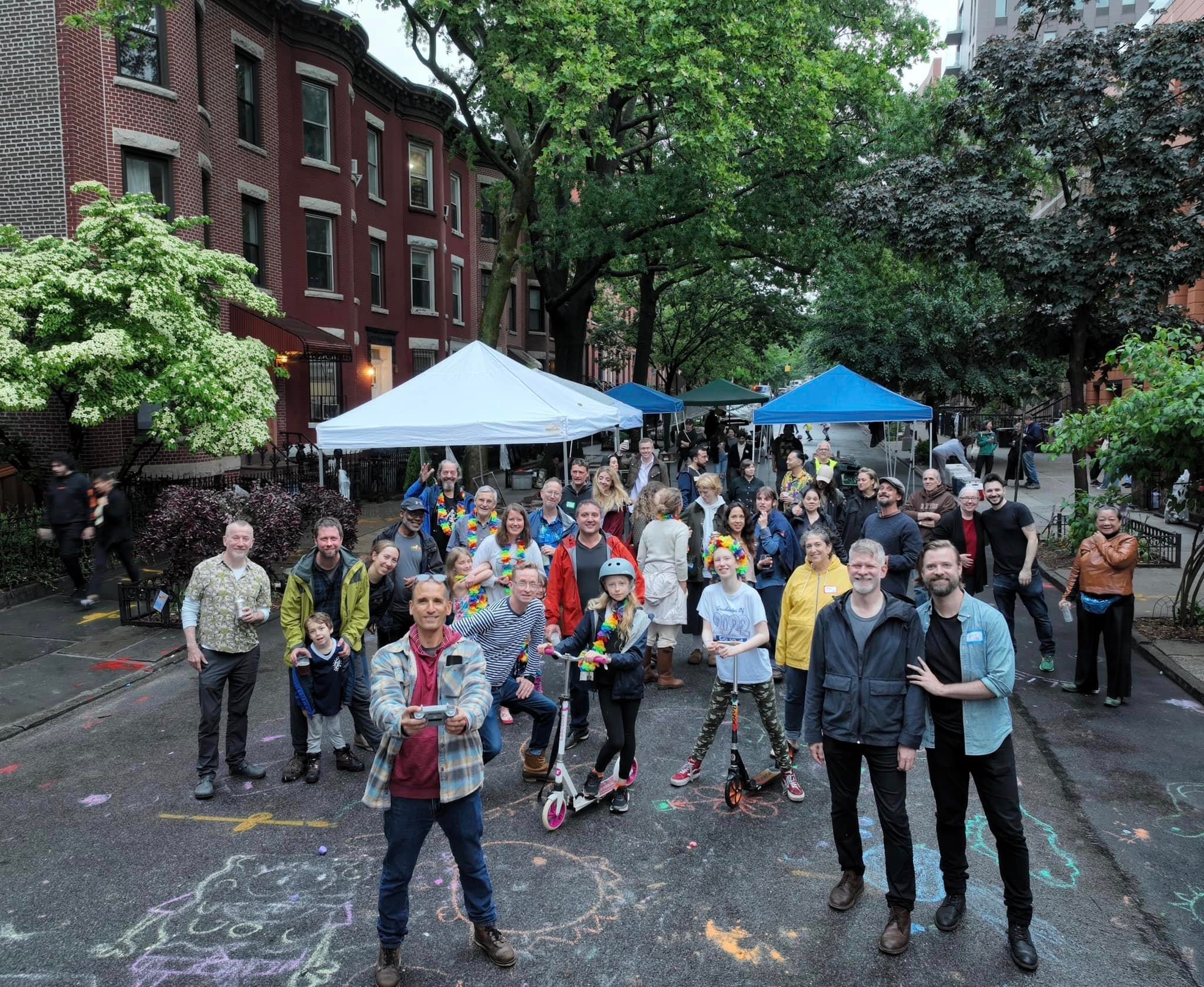 Neighbors gathered together in the street after a rainy Spring Block Party
